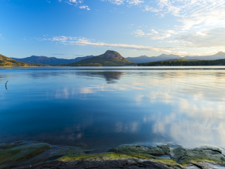 Still water of a lake showing the reflection of the sky